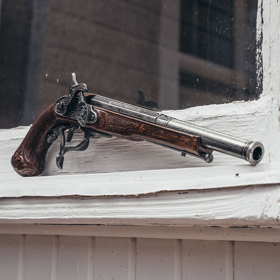 replica flintlock pistol leaning on a windowstill