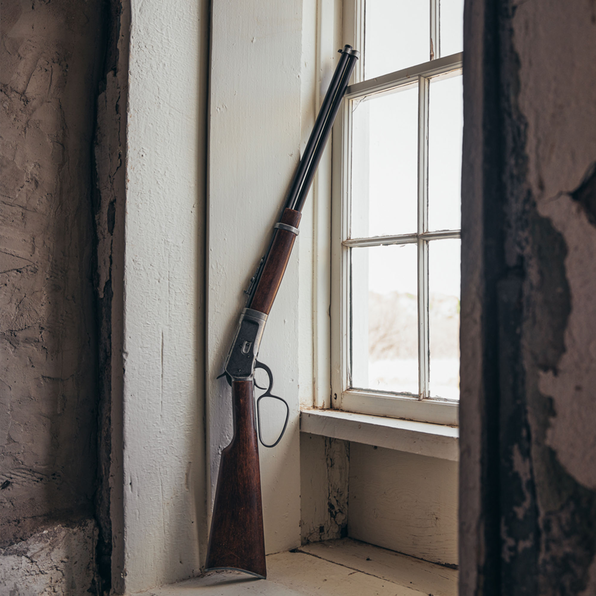 old west rifle replica leaning against a window