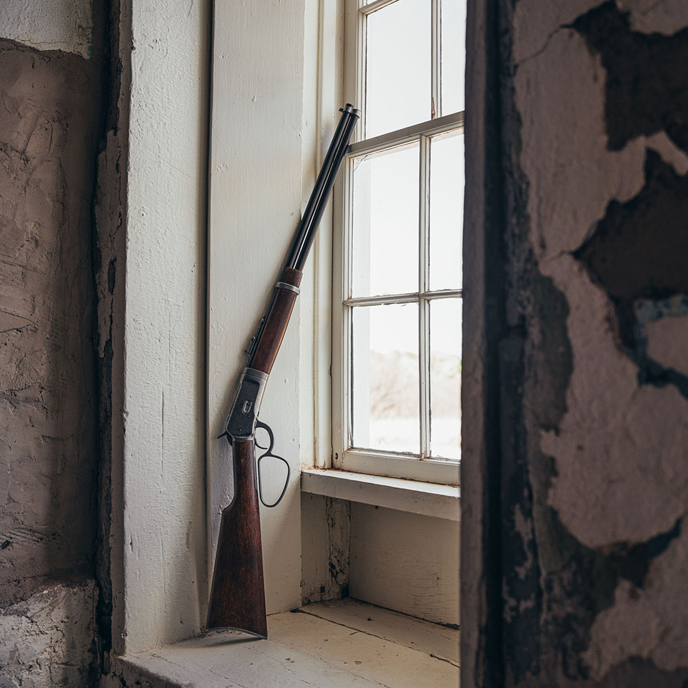 non firing old west rifle replica leaning on window