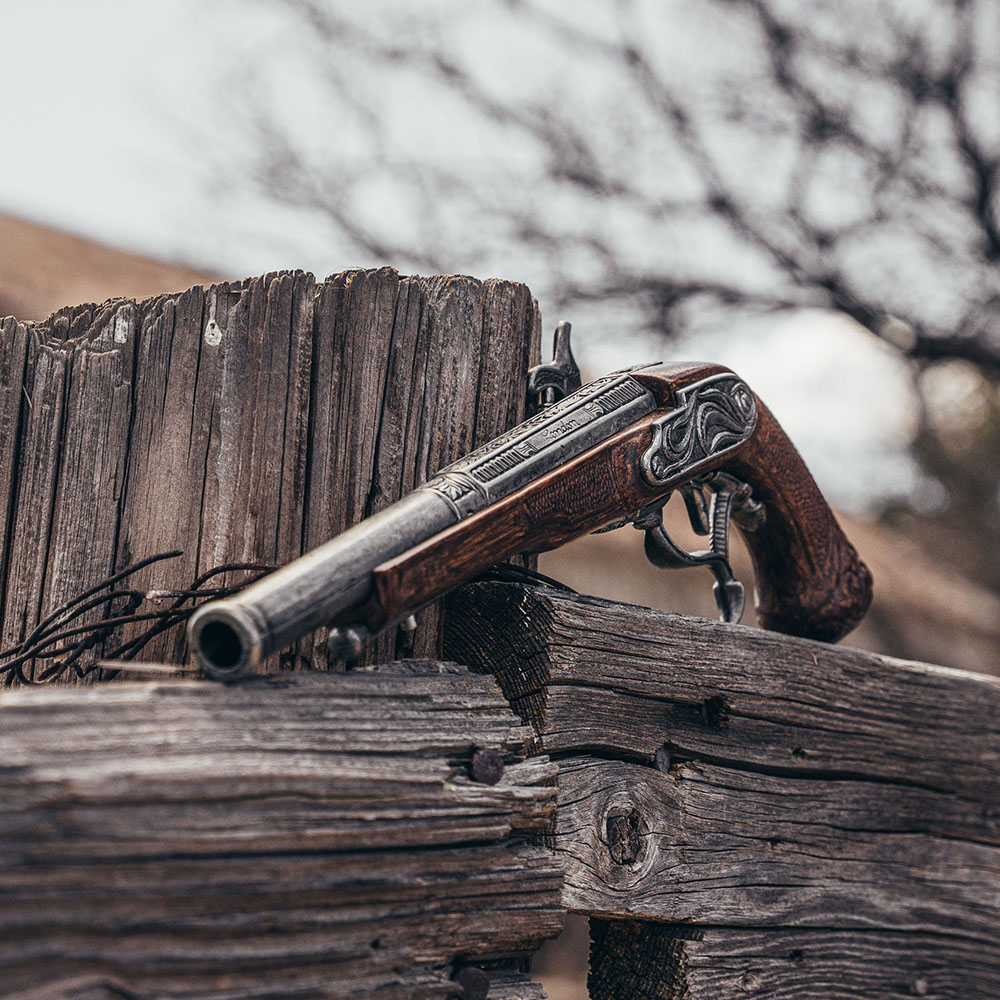 replica pirate percussion pistol on wooden rail