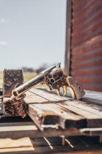 small old west pistol with a farm land background