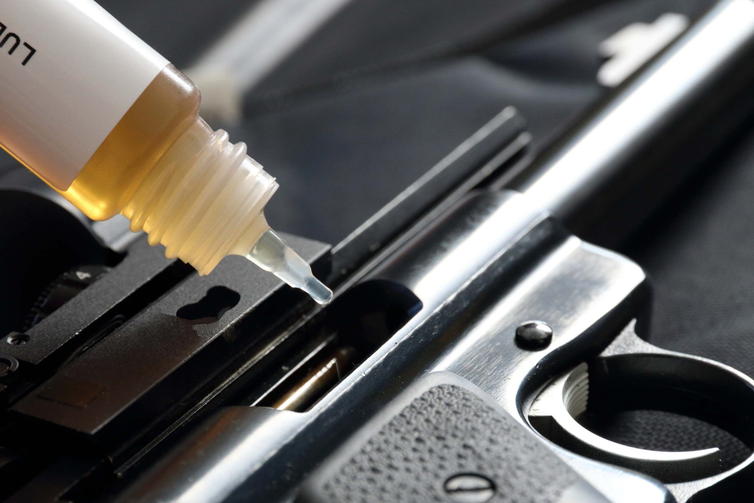 Close-up of a gun being lubricated with oil